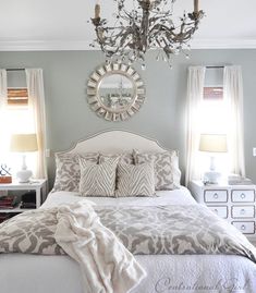 a bedroom with a chandelier hanging from the ceiling and a bed in front of it