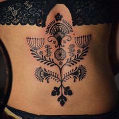 a woman's lower back tattoo with an intricate design on her stomach and side