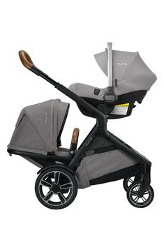 a baby stroller with a grey seat and brown handlebars