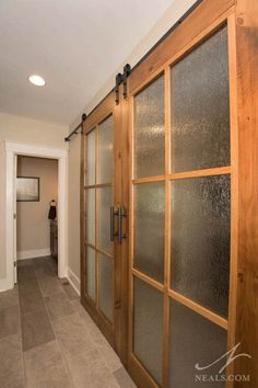 a person is standing in the hallway between two doors with frosted glass on them