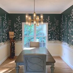 an empty dining room with green wallpaper and chandelier