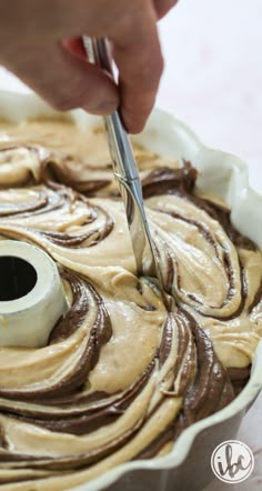 a person cutting into a chocolate swirl cake