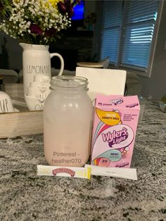 a glass jar sitting on top of a counter next to a package of toothpaste