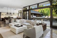 a living room filled with white furniture and lots of windows