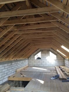 an attic with wooden flooring and exposed rafters on the ceiling, surrounded by wood planks