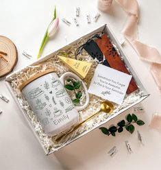 a gift box containing an empty coffee mug, tea and other personalized items for someone's special occasion