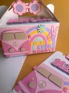 a cardboard box that has some kind of pink and yellow bus on it with peace signs