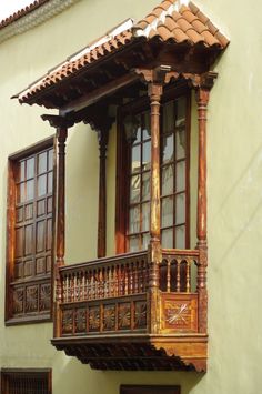 an ornate wooden balcony on the side of a building