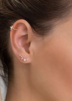 a woman wearing an ear cuff with three small leaves on the top of her ear