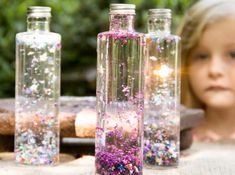 two empty bottles filled with confetti and sparkles sitting on top of a table