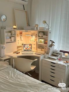 a bedroom with a bed, desk and computer on top of the dresser next to it