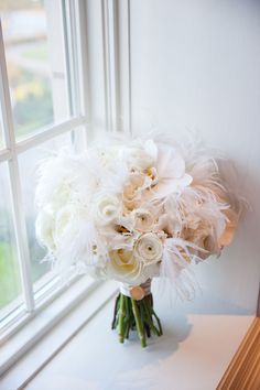 a bouquet of white flowers sitting on top of a window sill