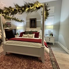 a bedroom with a canopy bed and christmas decorations