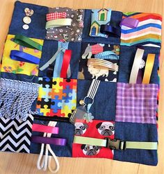 a piece of cloth covered in different types of colorful ribbons and ties on top of a wooden table