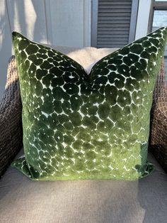 a green and white pillow sitting on top of a chair