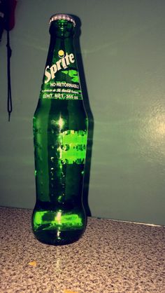 a green bottle sitting on top of a counter