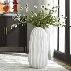 a white vase with some flowers in it