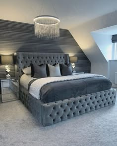 a large bed sitting under a chandelier in a bedroom