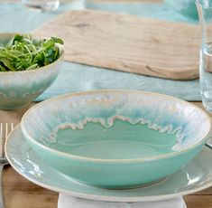 a table set with plates, bowls and utensils