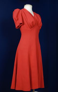 This dress is hand-made and is based on a 1940's sewing pattern. The dress features an empire waistline with draping under the bust, short puffy sleeves with small darts for extra shape, and a wide flared hemline that'll swirl beautifully as you dance. There is a zipper on the side. The material is a heavy viscose blend crepe in bright red or burnt orange. It has a beautiful heavy drape and movement. Dry cleaning is recommended for this dress. MEASUREMENTS PLEASE READ CAREFULLY BEFORE PURCHASING Fitted A-line Dress With Gathered Neckline, Fitted Cocktail Dresses With Gathered Neckline, Fitted Midi Dress With Empire Waist And Lined Bodice, Fitted Midi Dress With Lined Bodice And Empire Waist, Red Fitted Dress With Lined Bodice, Solid Color Fitted Knee-length Vintage Dress, Fitted Empire Waist Midi Dress For Cocktail, Fitted Dress With Gathered Neckline, Red Dresses With Fitted Bodice For Dressmaking