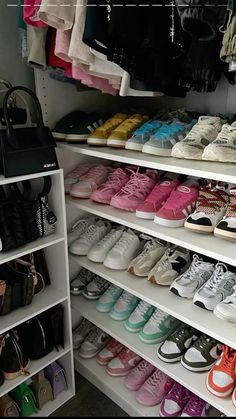 there are many shoes and purses on the shelves in this closet, all lined up