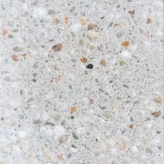 a close up view of the surface of a concrete slab with small rocks and pebbles