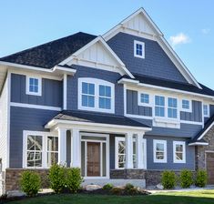 a large gray house with white trim and windows