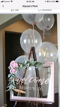 balloons and flowers are hanging from a sign