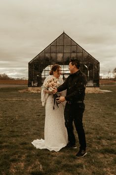 a bride and groom are standing in the grass