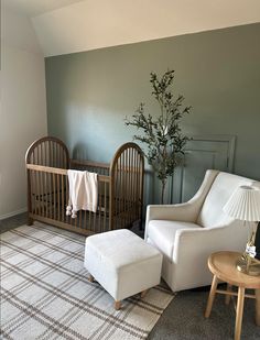 a baby's room with a crib, chair and ottoman