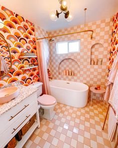 a bathroom with pink and orange tiles on the walls