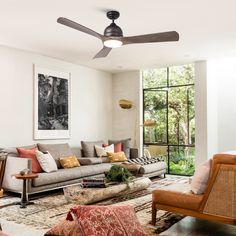 a living room filled with furniture and a ceiling fan