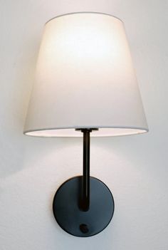 a wall lamp with a white shade on it