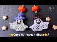 two halloween ghost beaded earrings with pumpkins and stars in the background on a black surface