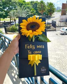 a person holding up a card with a sunflower on it that says feli's me to come