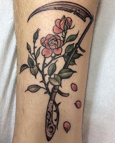 a tattoo on the leg of a person with flowers and a knife stuck in it