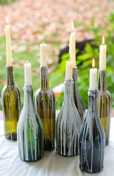 several bottles with candles in them sitting on a table