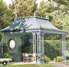 a gazebo sitting in the middle of a lush green park