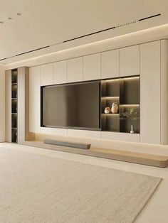 an empty living room with a large flat screen tv mounted on the wall and built - in shelving