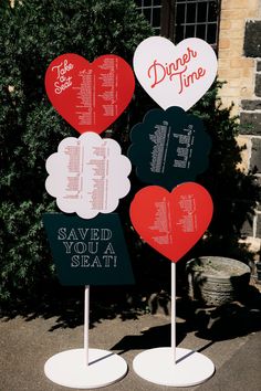 three heart shaped signs are standing in front of a tree with the words dinner time written on them