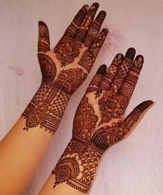 two hands with henna designs on them