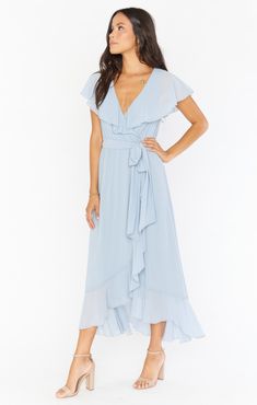 The Jess Ruffle Midi Dress is an easy to wear mock wrap dress that gives you the flattering appearance of a wrap but the security of an elastic waist and sash. Her ruffled v-neckline is long enough to cover your the top of your arms for a flirty flounce! She has a high-low hemline to show of your shoes with a gentle ru Elegant Light Blue Midi Dress With Ruffle Hem, Light Blue Casual Midi Dress With Ruffles, Fitted Light Blue Midi Dress With Ruffle Hem, Flowy Light Blue Midi Dress With Ruffles, Blue V-neck Midi Dress With Ruffles, Bridesmaid Dresses Midi, Steel Blue Bridesmaid Dresses, Maternity Dress Outfits, Light Blue Bridesmaid Dresses