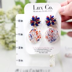 a pair of earrings with red, white and blue sprinkles on them