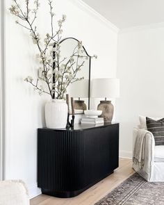 a living room filled with furniture and a mirror on top of a dresser next to a couch