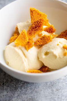 a white bowl filled with ice cream and orange peels