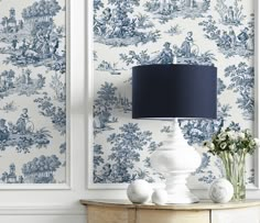 blue and white toiler wallpaper in a living room with a lamp on the side table