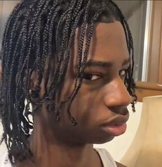 a close up of a person with dreadlocks on their head and wearing a white tank top