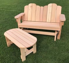 a wooden bench and table sitting in the grass