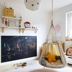 a child's bedroom with a chalkboard and hanging hammock