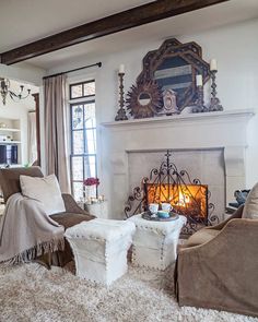 a living room filled with furniture and a fire place in front of a mirror on the wall